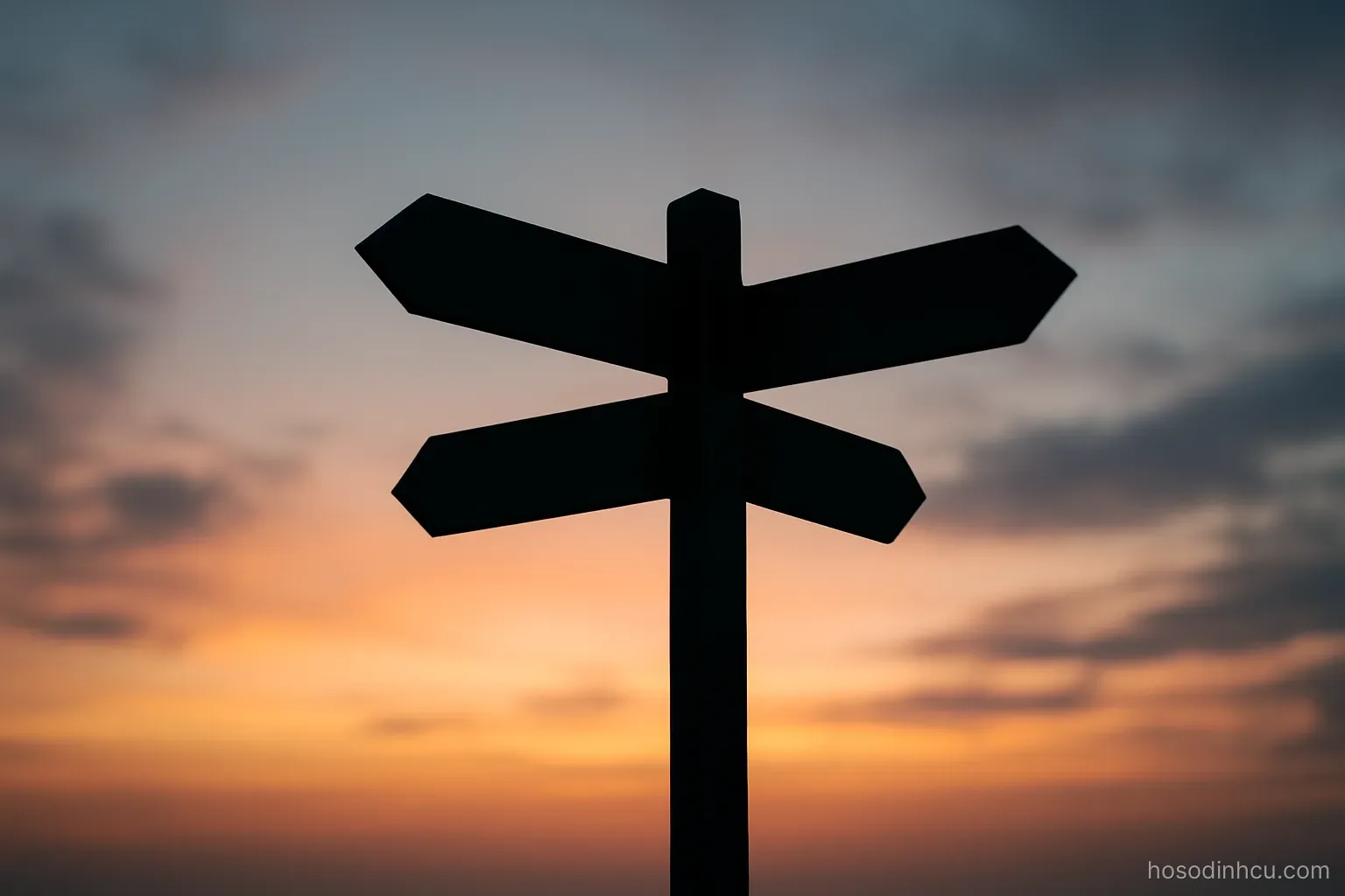 a crossroads sign post silhouette against an evening sky, arms blank without any writing